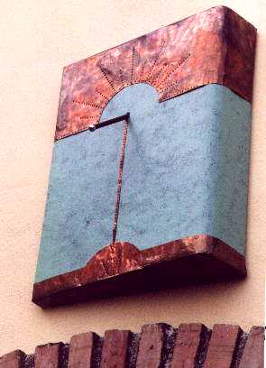 Particolare della meridiana : la meridiana  realizzata con un sportello di un mobile in legno, dipinta con vernici naturali biocompatibili e rifinita con applicazioni in rame